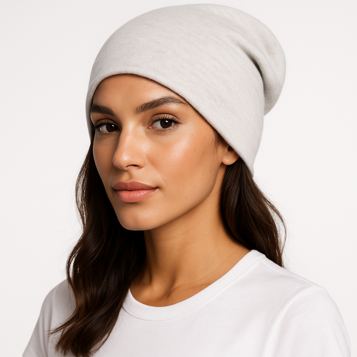 Woman wearing a light gray emf 5g shielding beanie on a white background